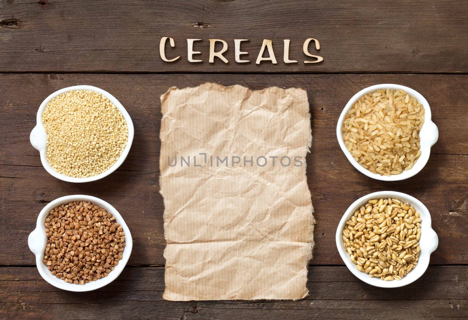 Cereals in bowls with word Cereals and paper on wooden background
