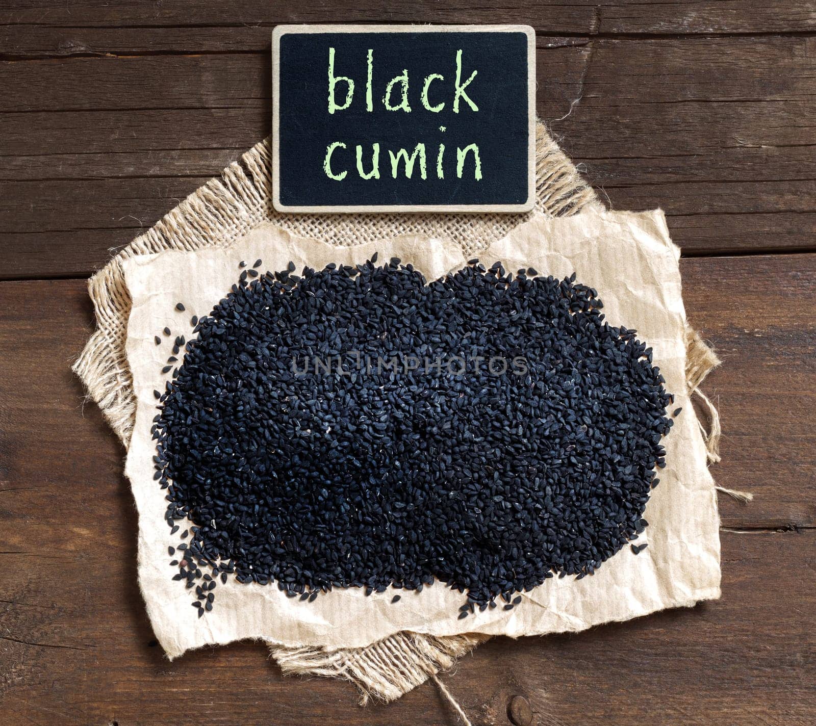 Plie of Nigella sativa or Black cumin on a wooden table