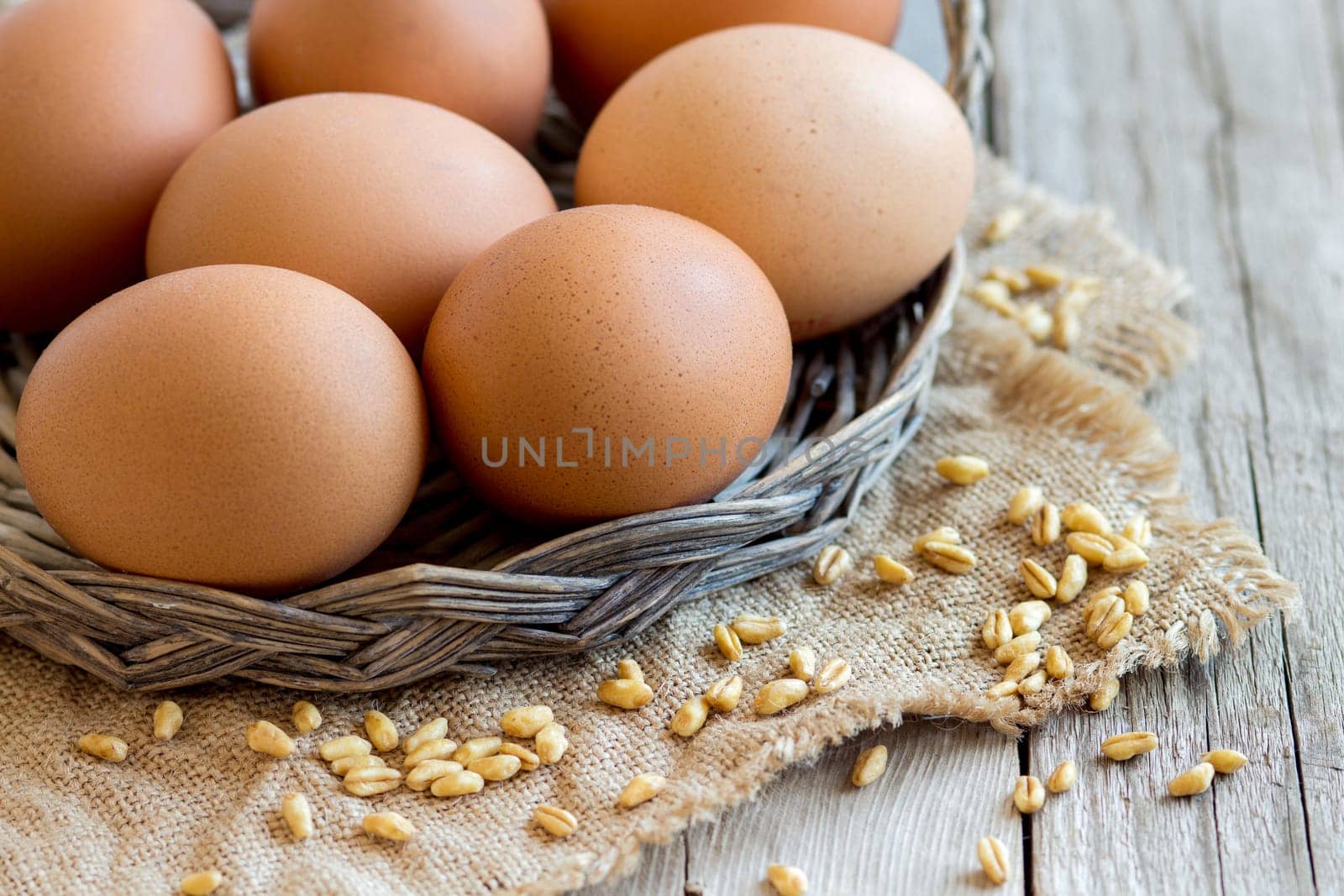 Chicken eggs and wheat on the old wooden table