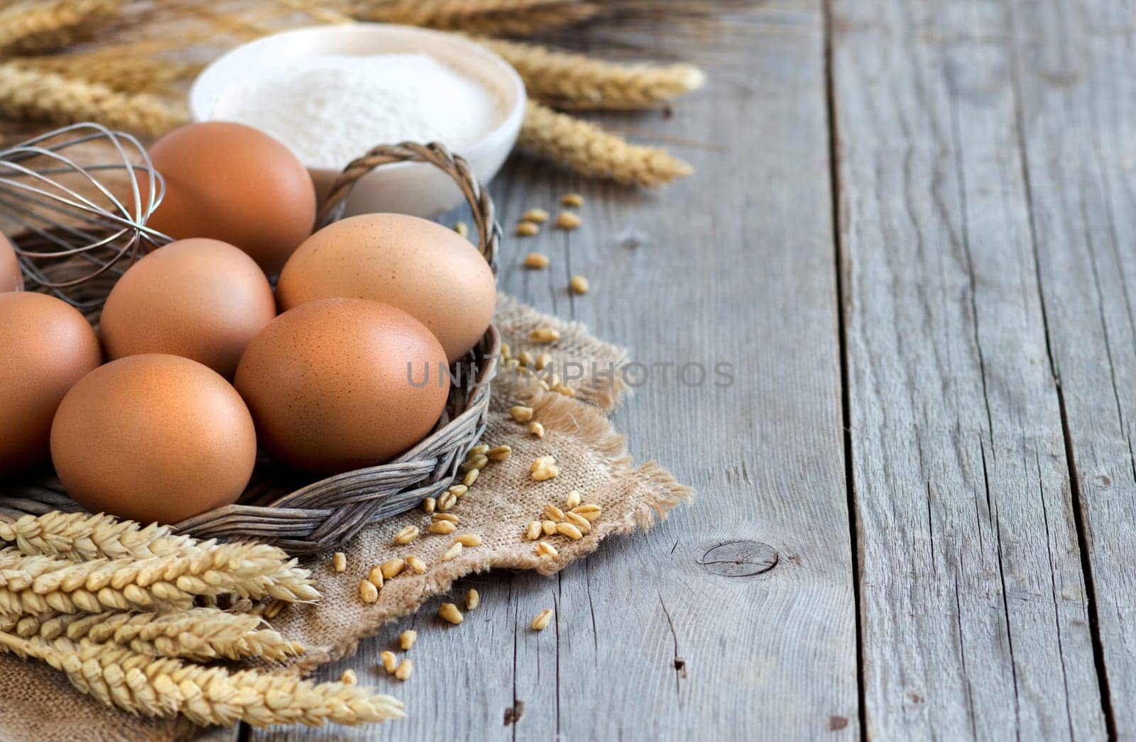 Chicken eggs, wheat and flour on the old wood