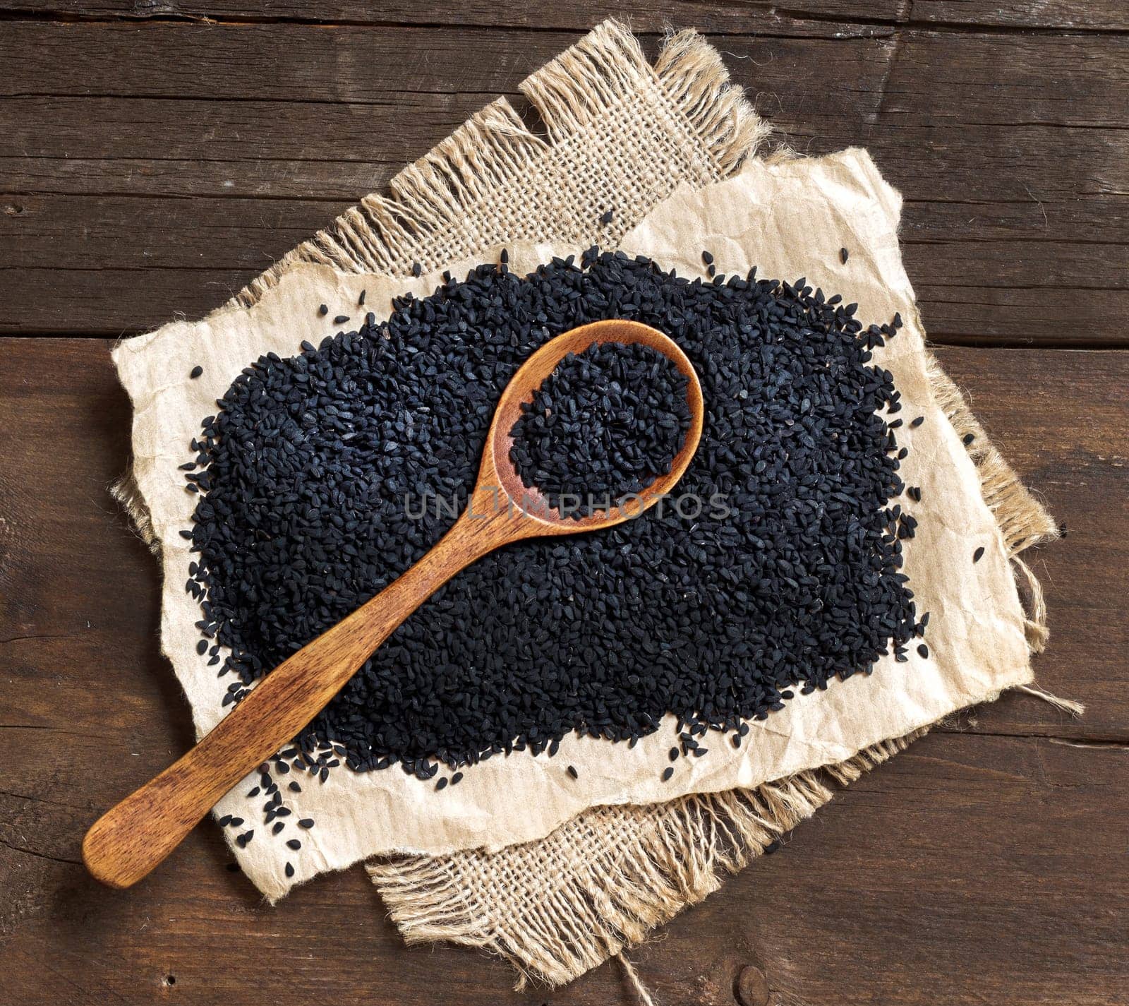 Nigella sativa or Black cumin with a spoon in wood