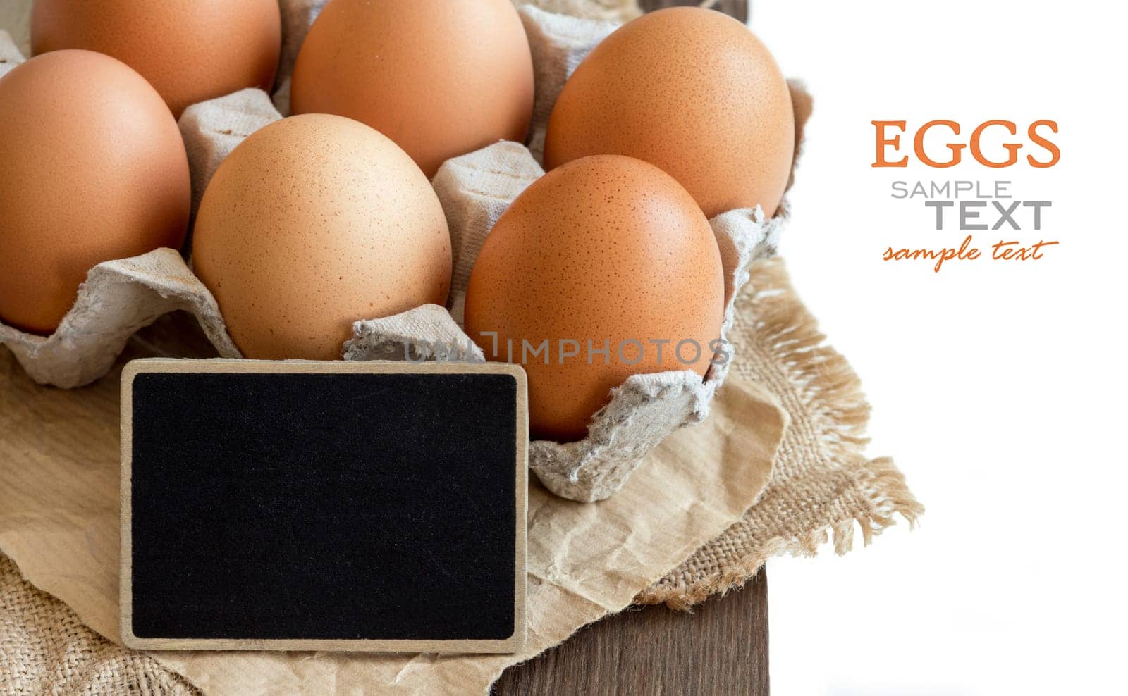 Chicken eggs in the package and small chalkboard close up