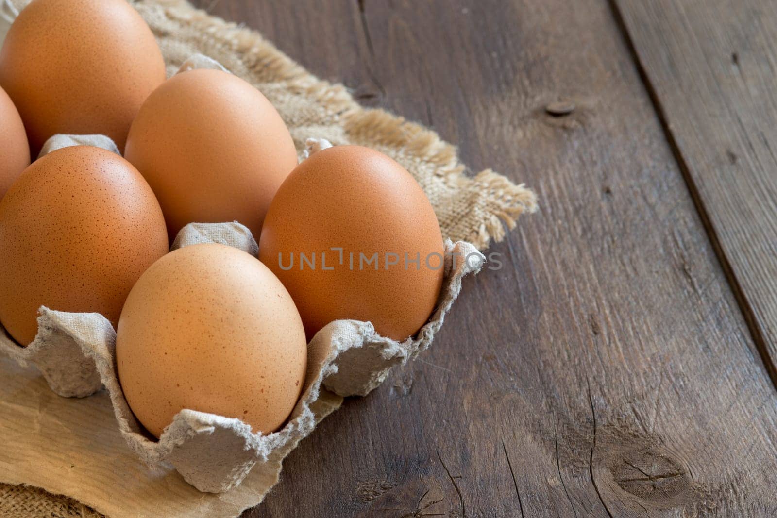 Chicken eggs in the package on the old wooden table