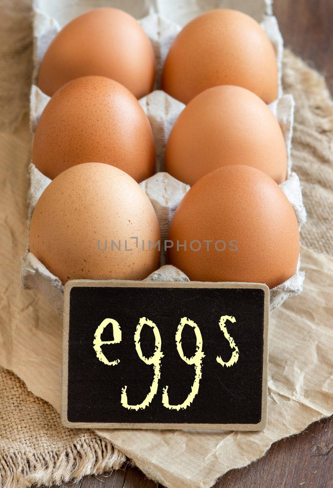 Chicken eggs in the package and small chalkboard close up
