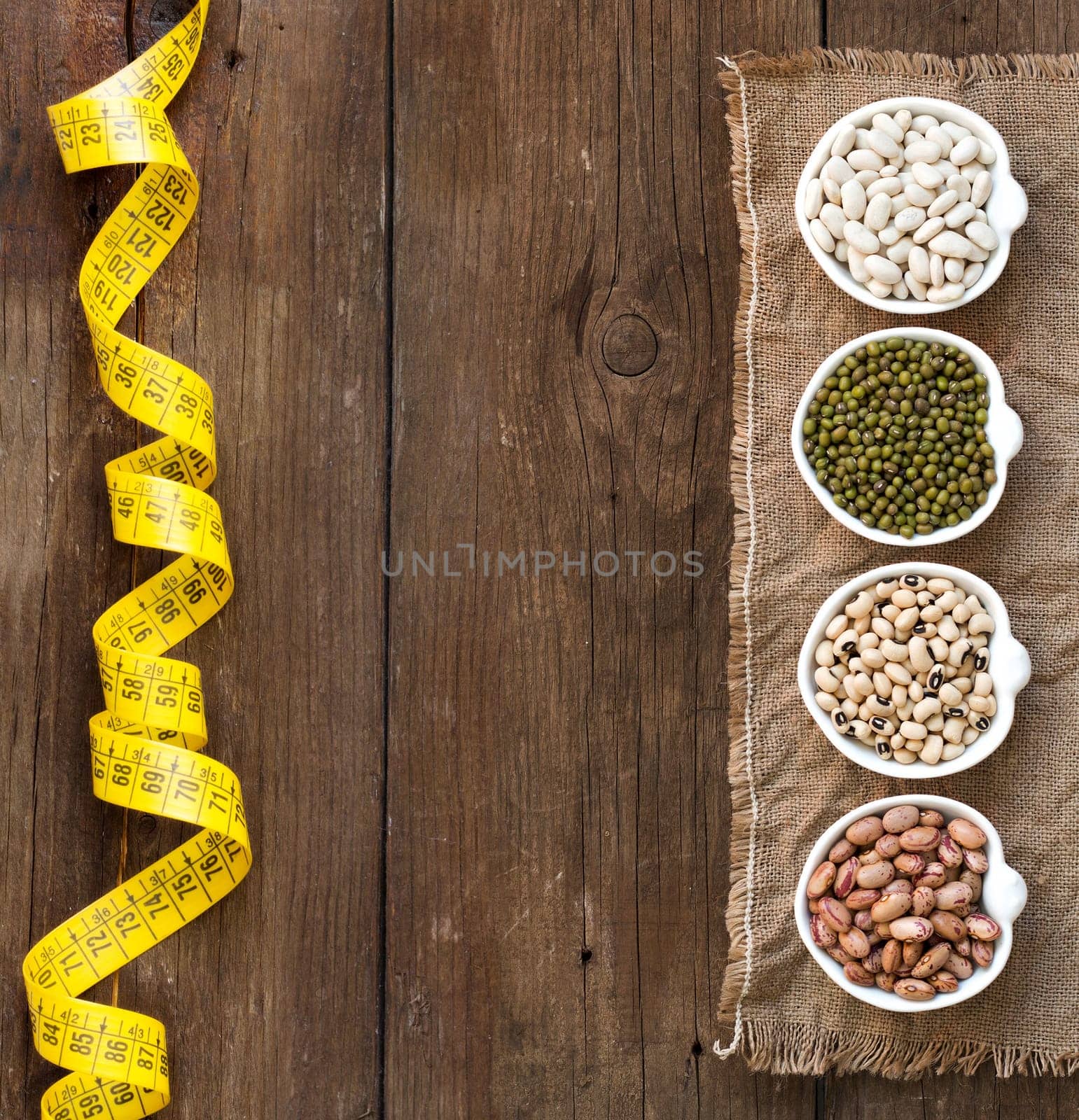 Assortment of legumes in bowls on wooden table