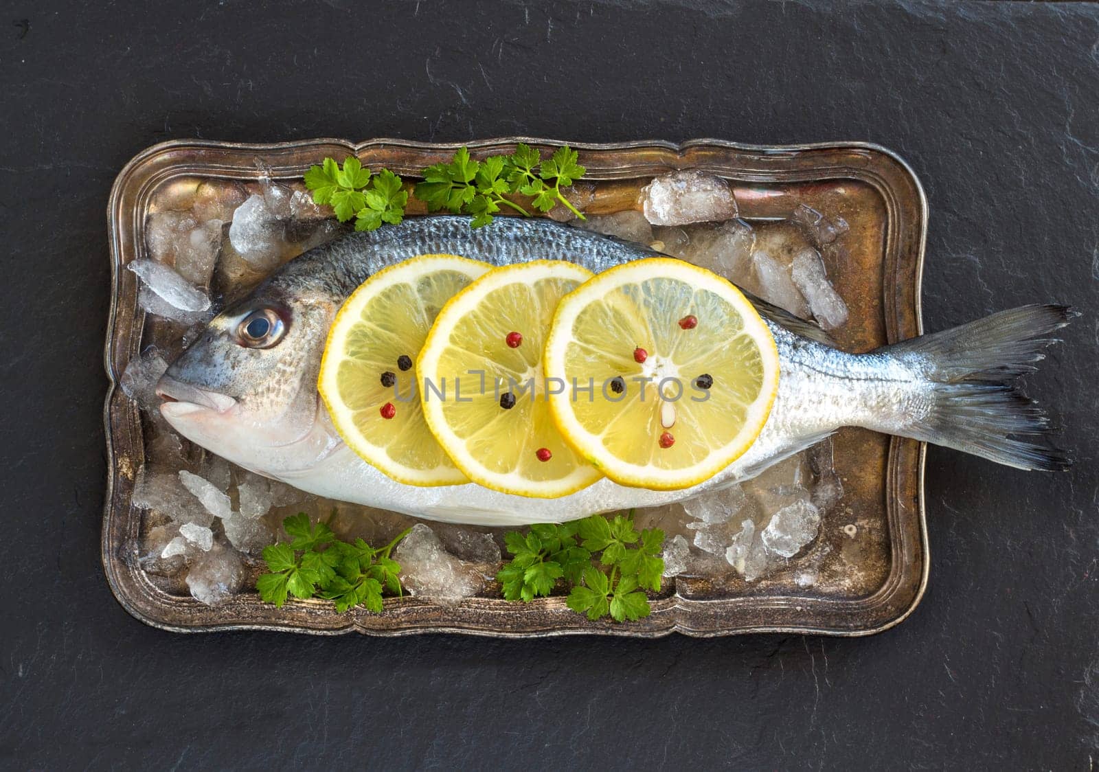 Fresh dorado fish on ice on vintage silver tray