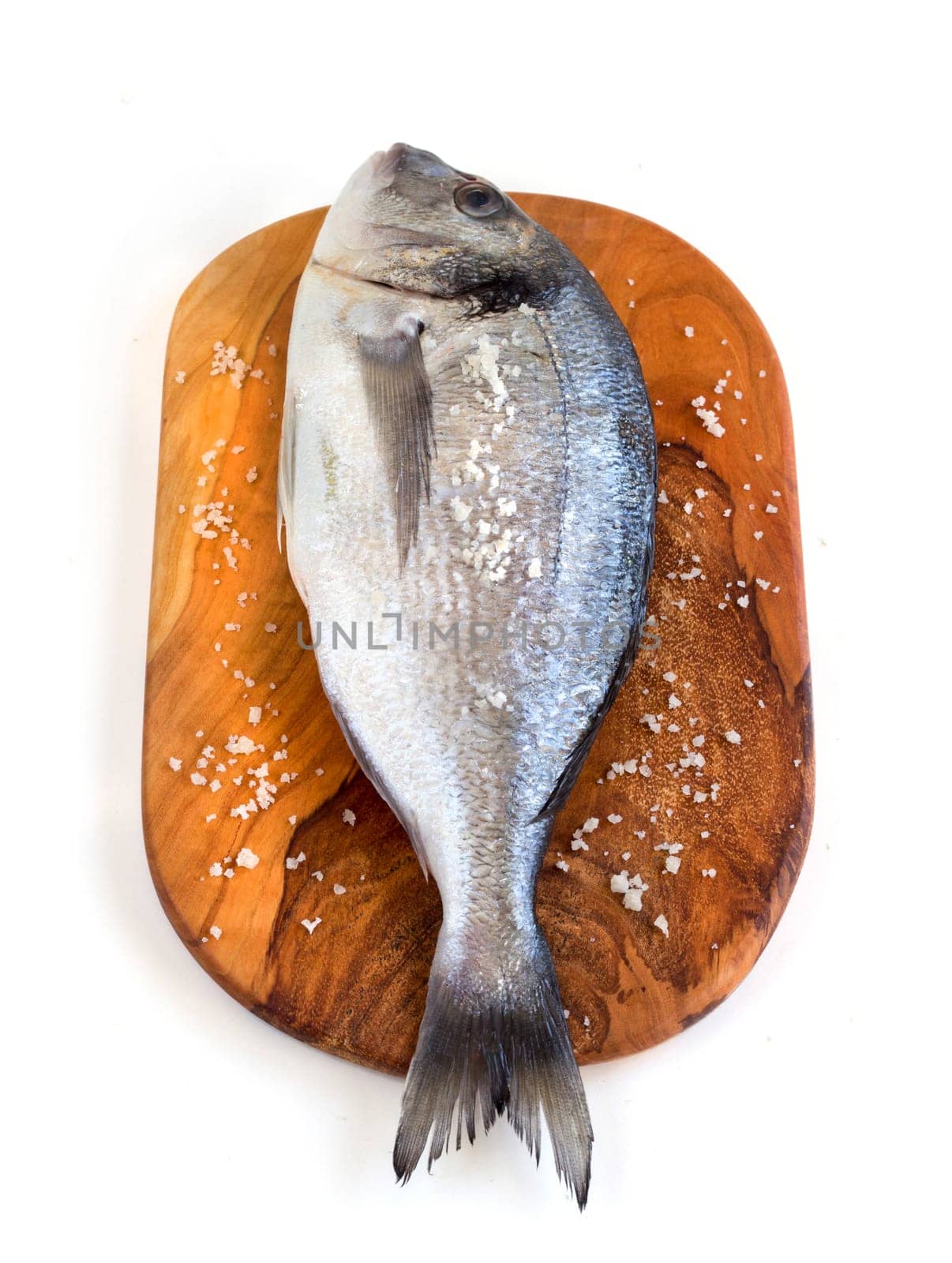 Fresh dorado fish on a cutting board isolated on white