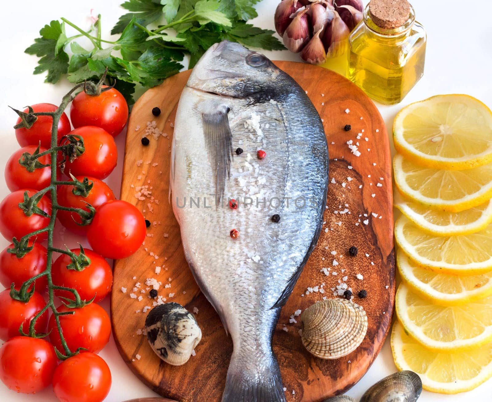 Fresh dorado fish, seafood and vegetables on a white background