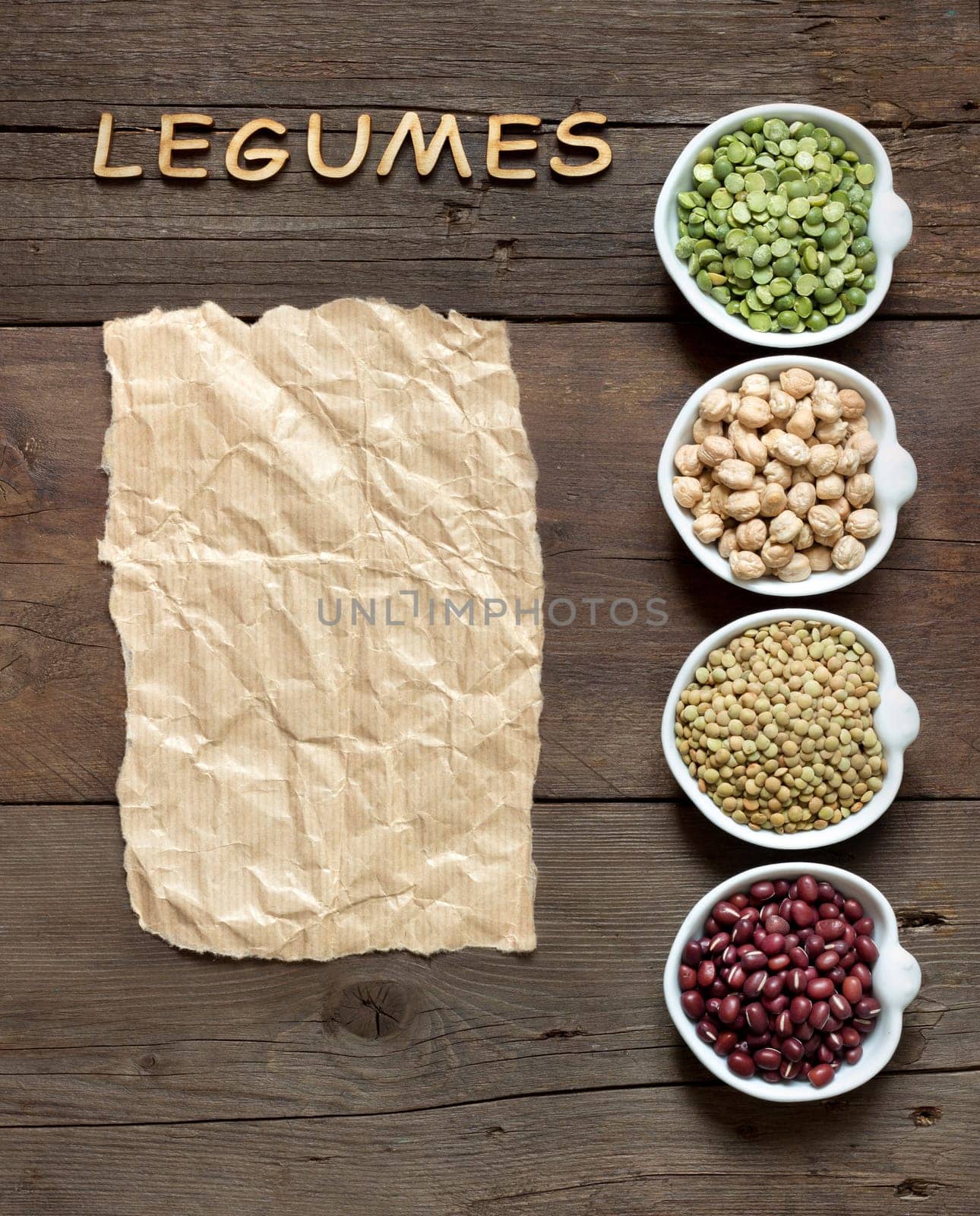 Variety or legumes, word Legumes and paper on a wooden table