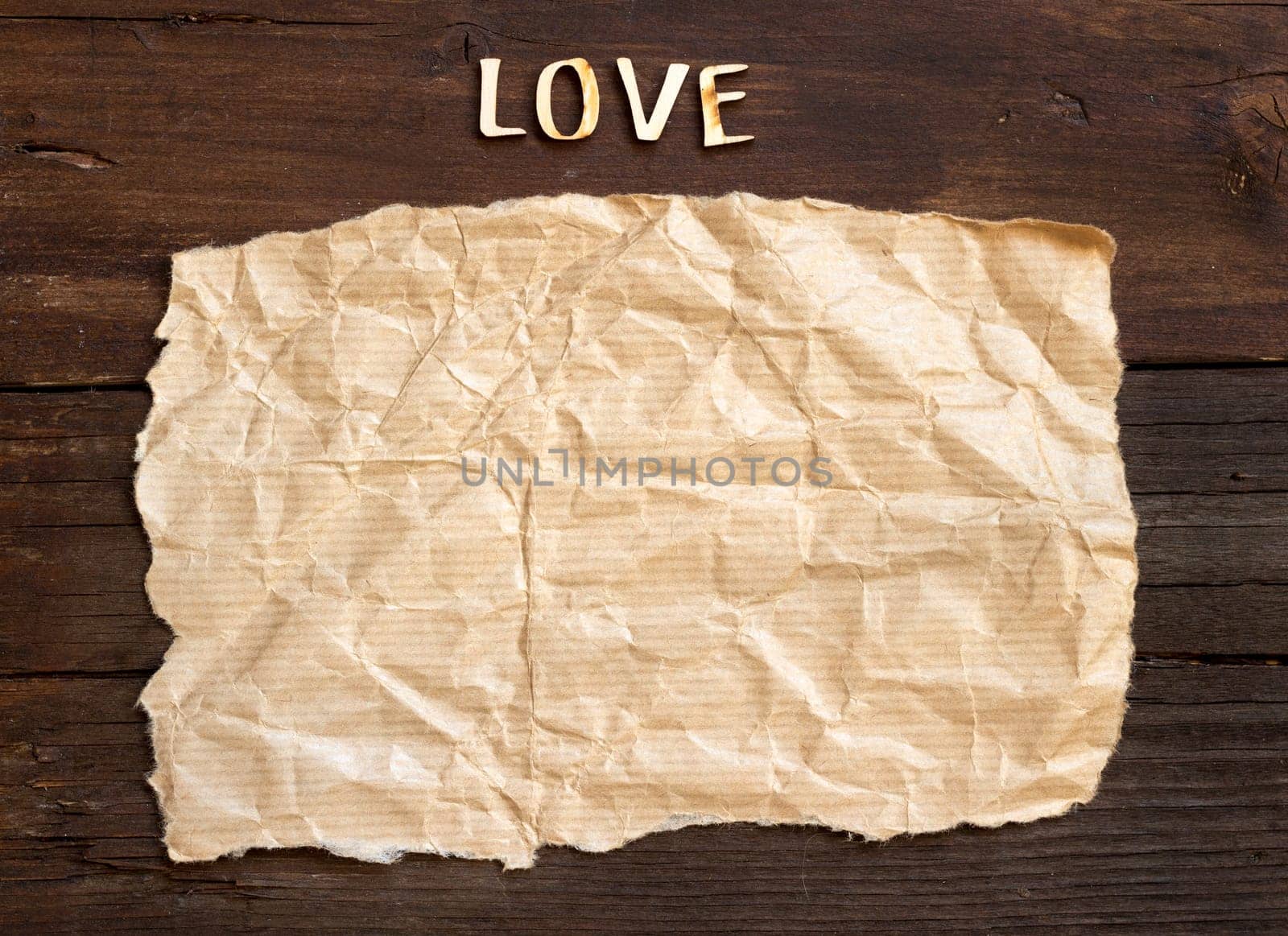 Word love and paper on old wooden background