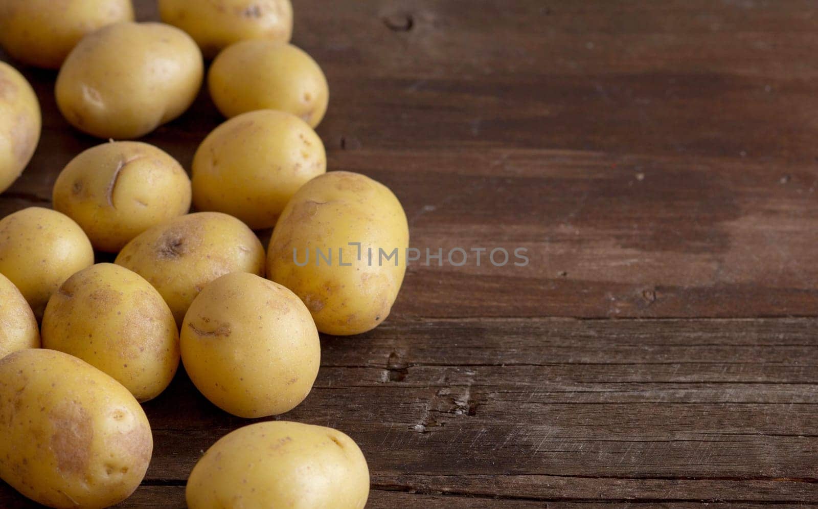 Young small potatos on wooden background border