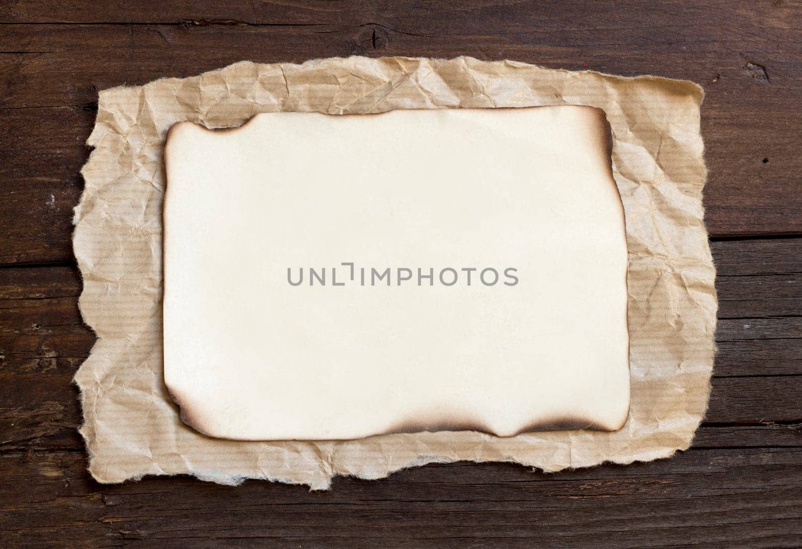 Old burned paper on the wood background