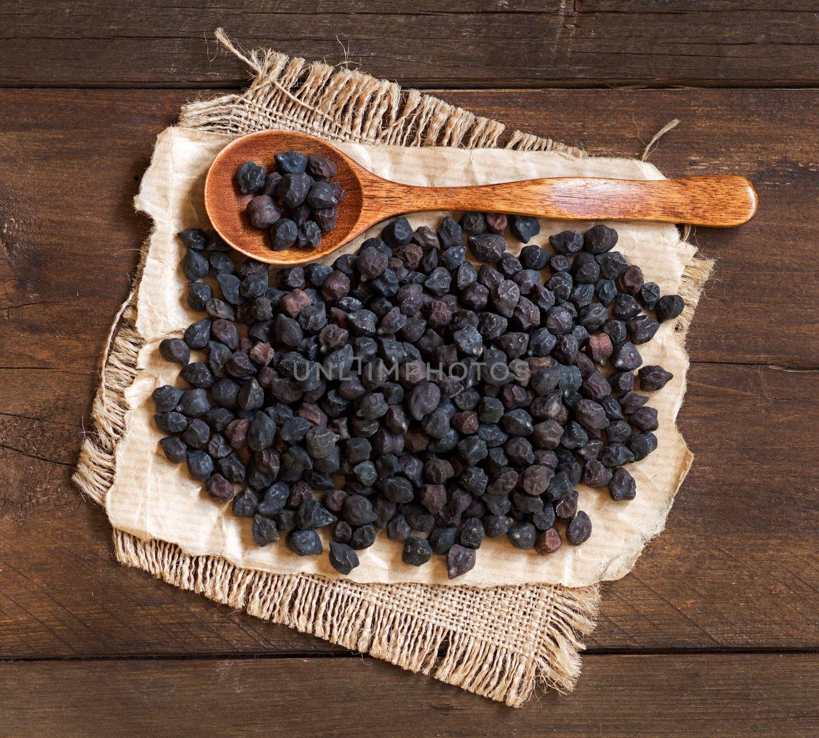 Pile of Black Chickpea with a spoon on a wooden background