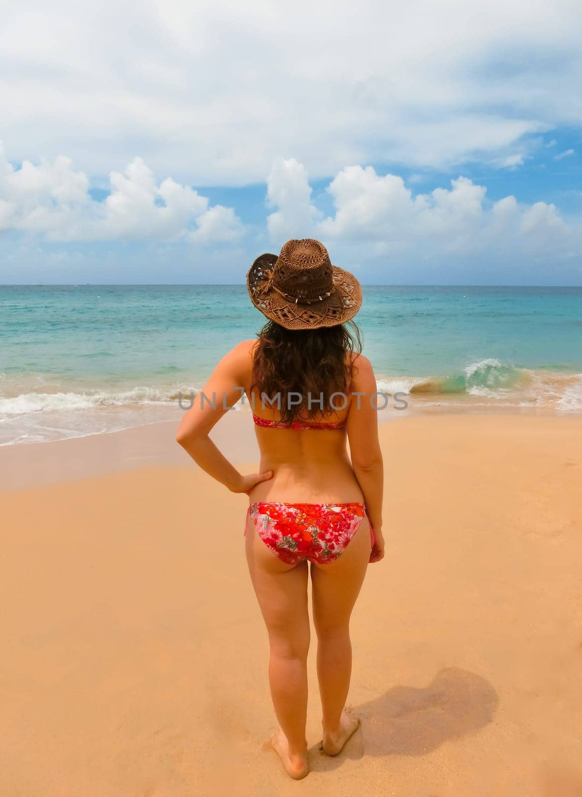 Young woman with hat on sand beach