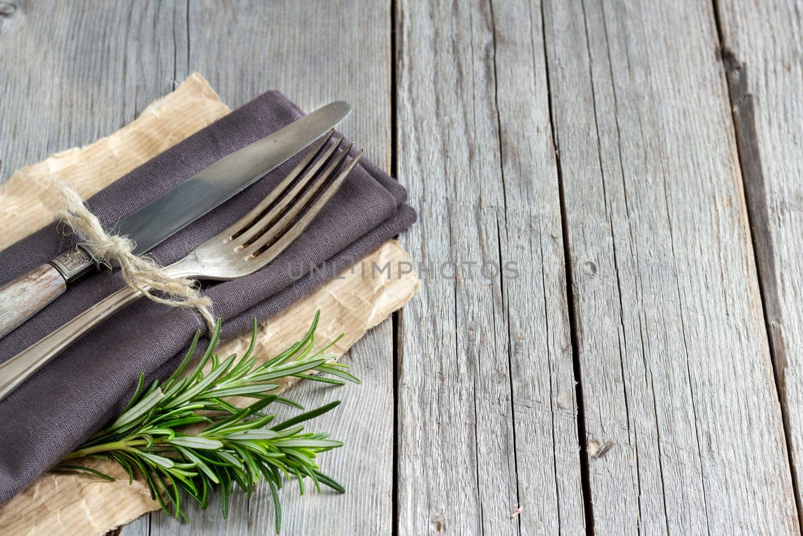 Vintage Table setting with rosemary decor on old wooden table