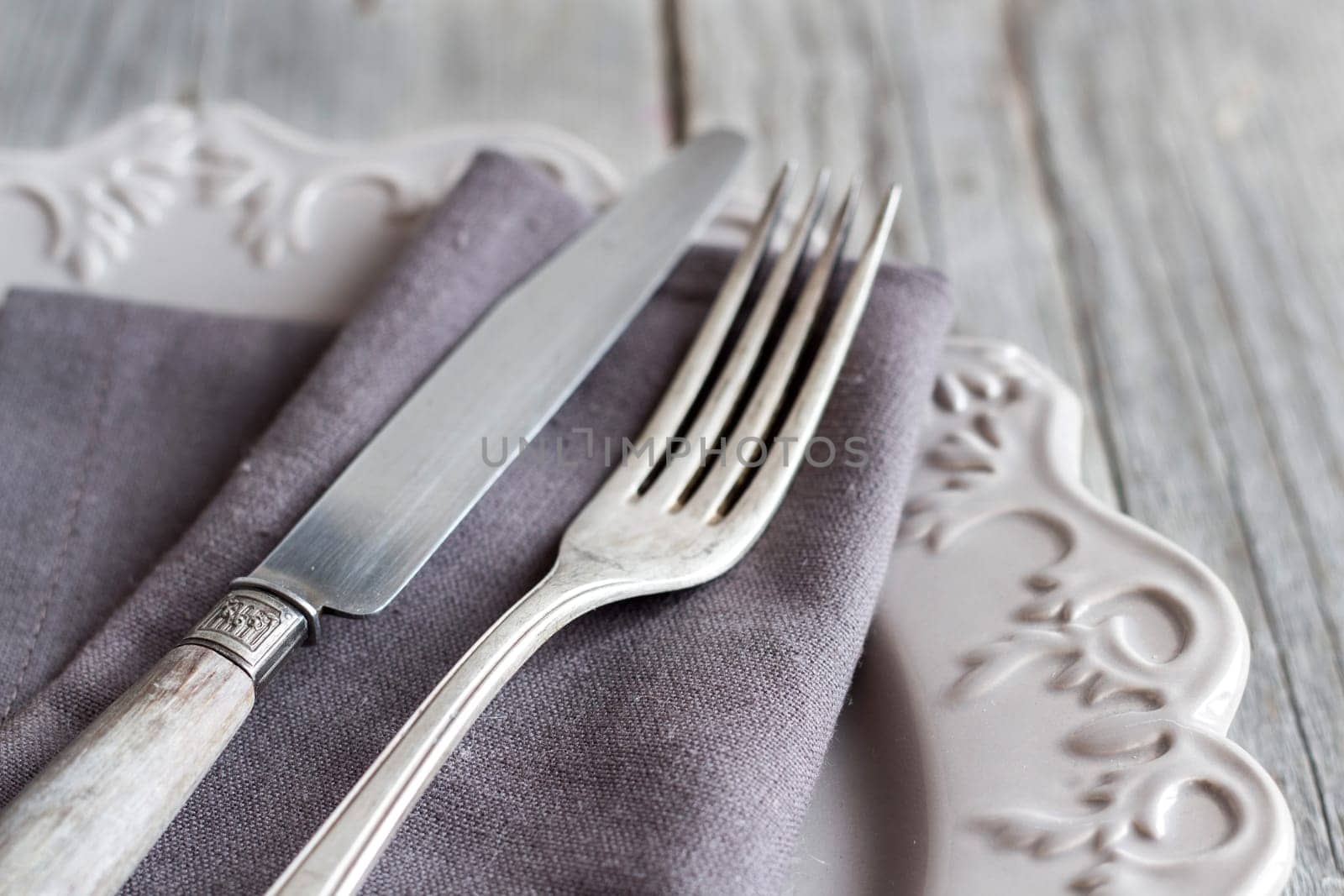Vintage Table setting with napkin and plate on old wooden table