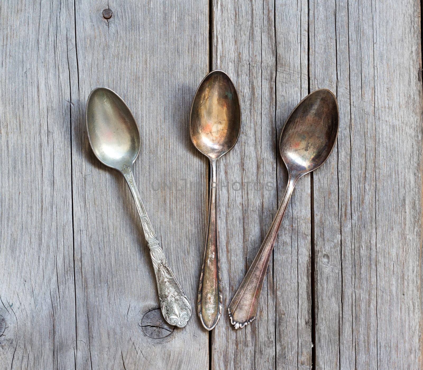 Vintage spoons with patina on old wooden table