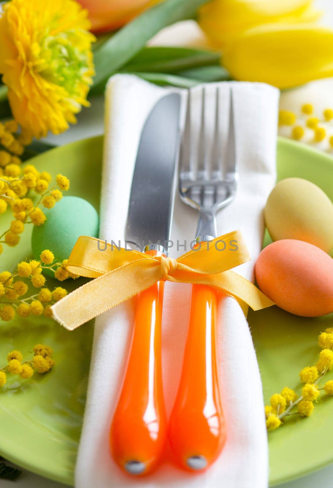 Easter table setting with yellow tulips and mimosa
