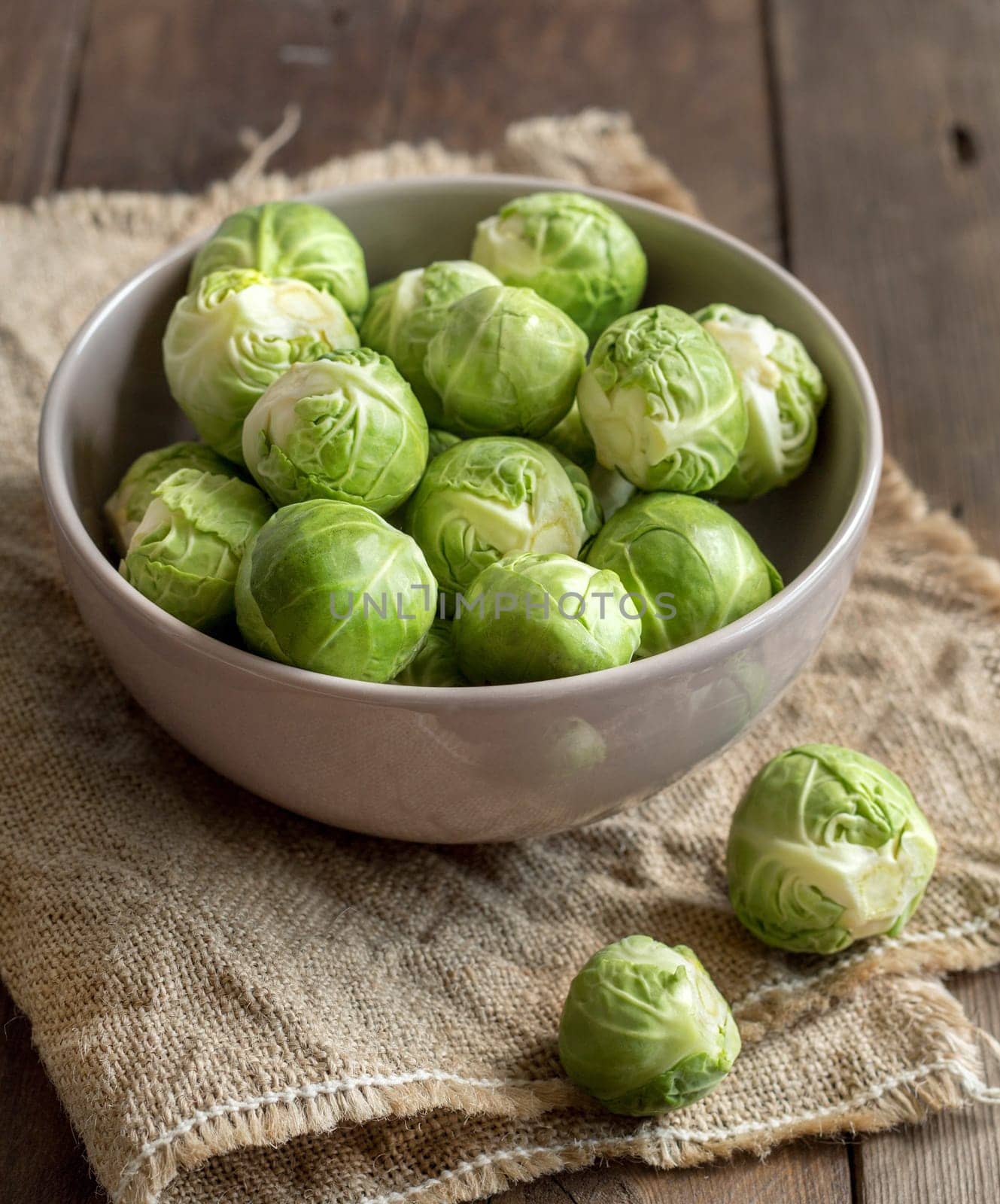 Brussels sprouts in a bowl on burlap on a wooden table