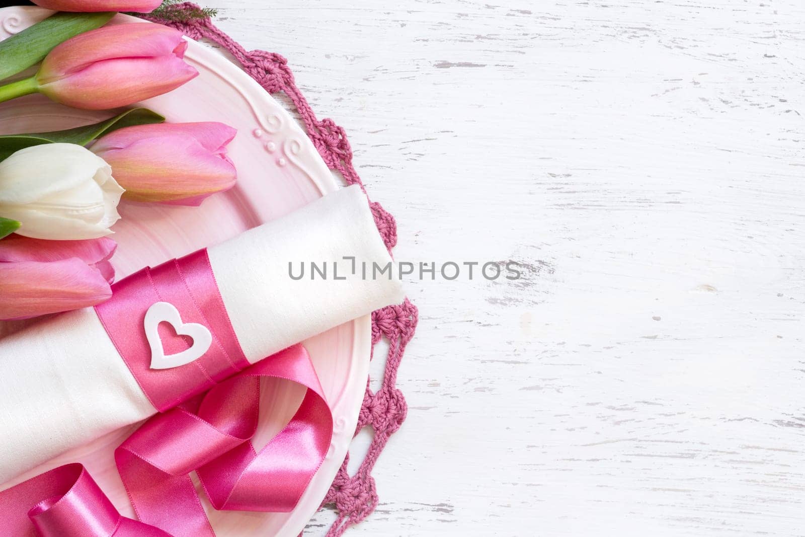 Festive spring table setting with pink flowers and ribbon