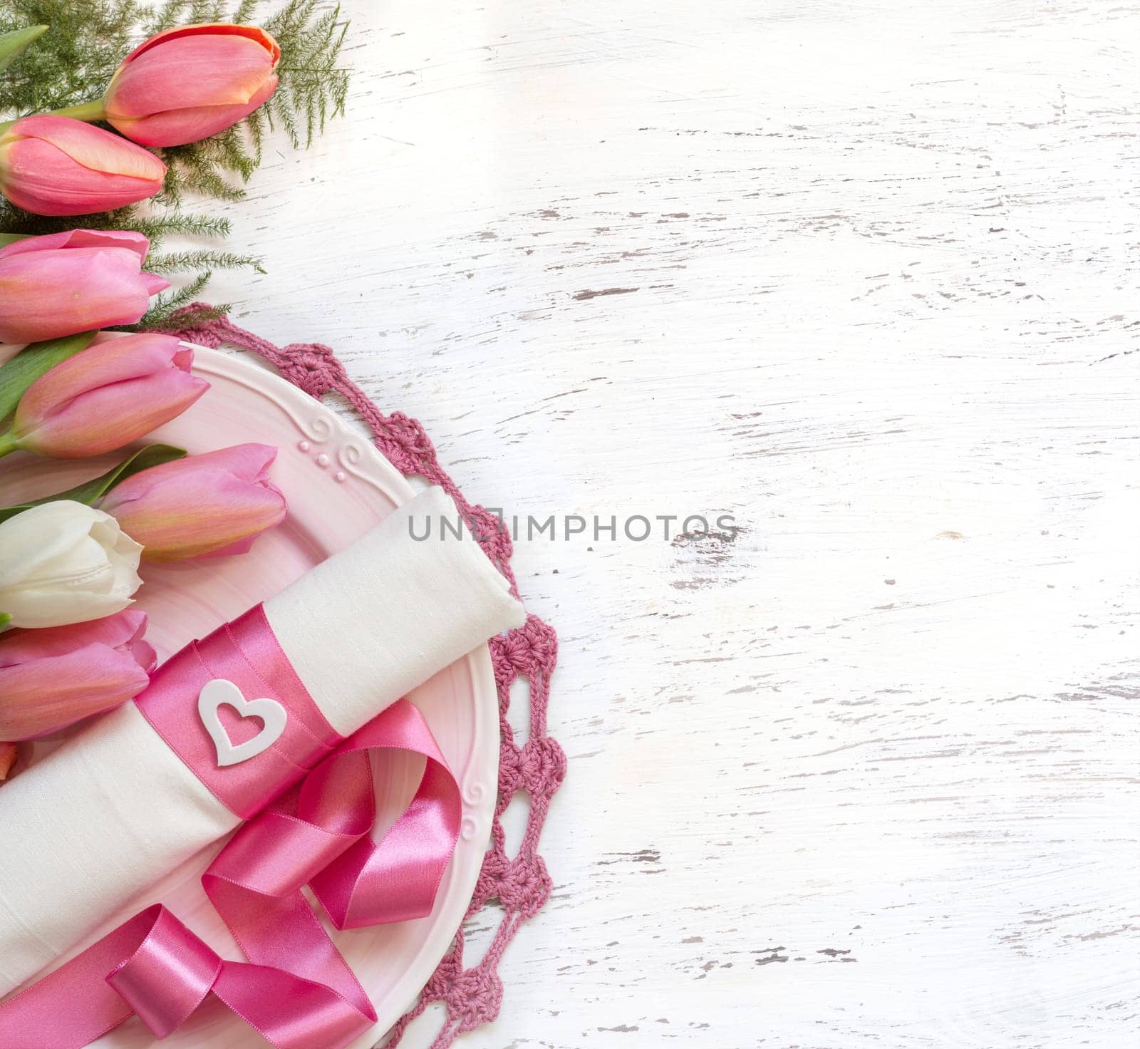 Festive wedding table setting with pink tulips and ribbon