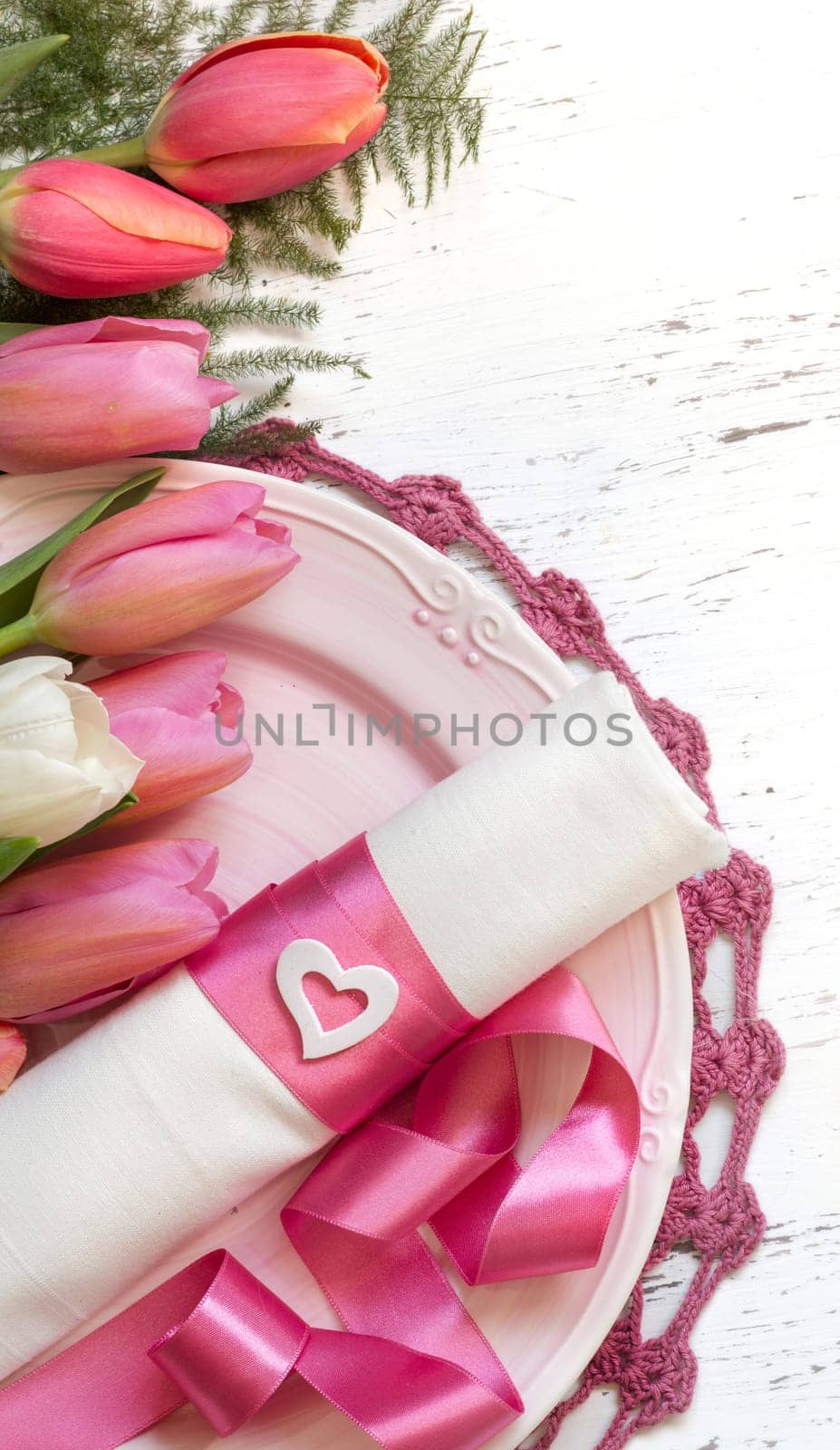 Festive spring table setting with pink flowers and ribbon