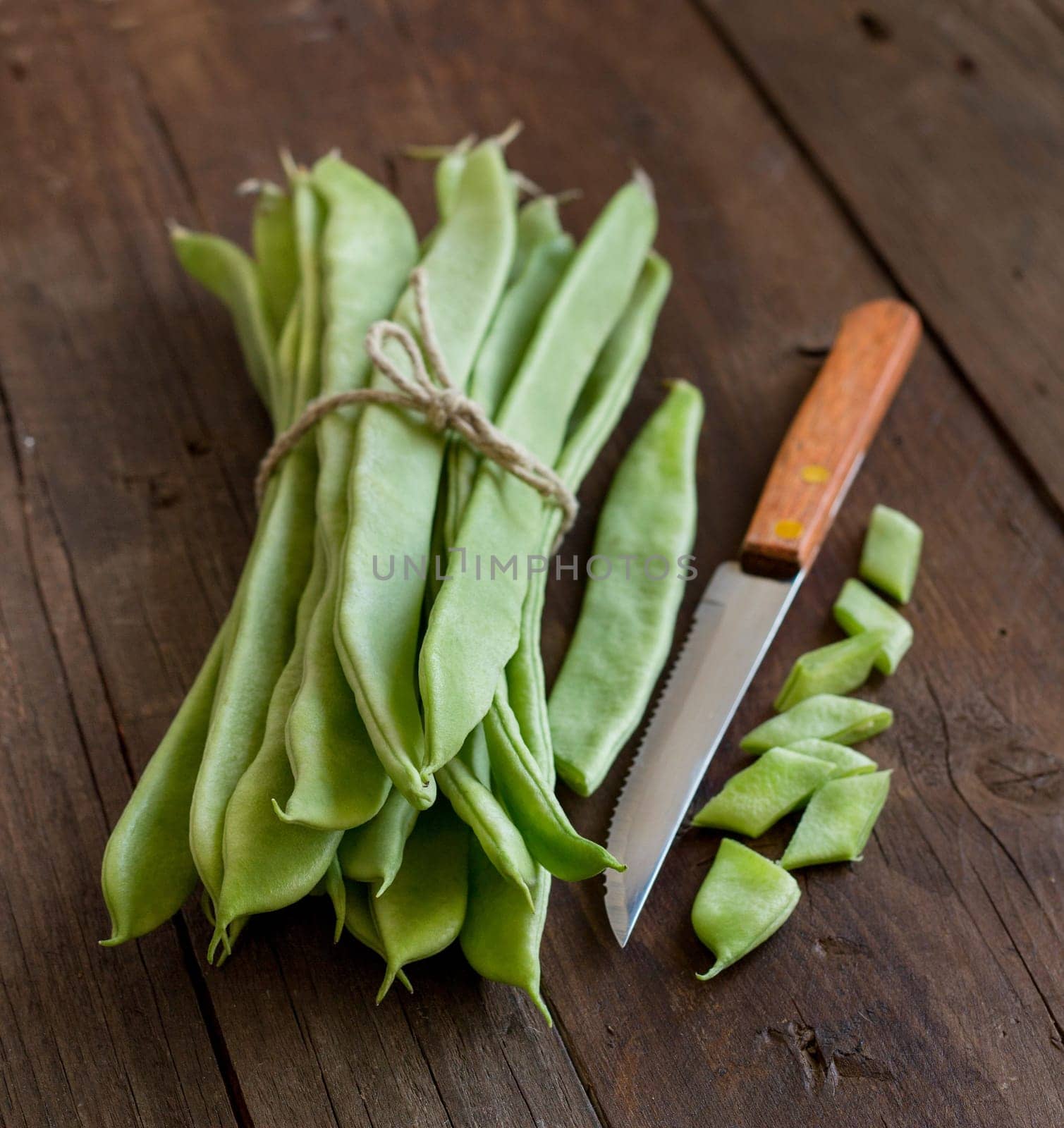 Piattoni green beans with knife on the old wooden table