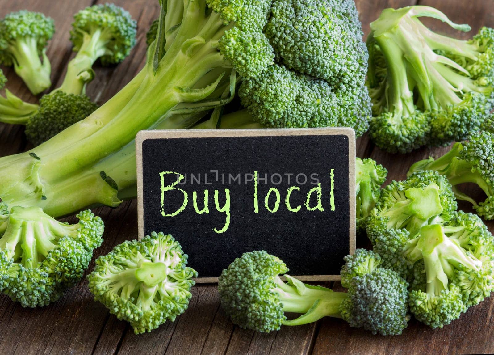 Fresh broccoli small chalkboard on old wooden table