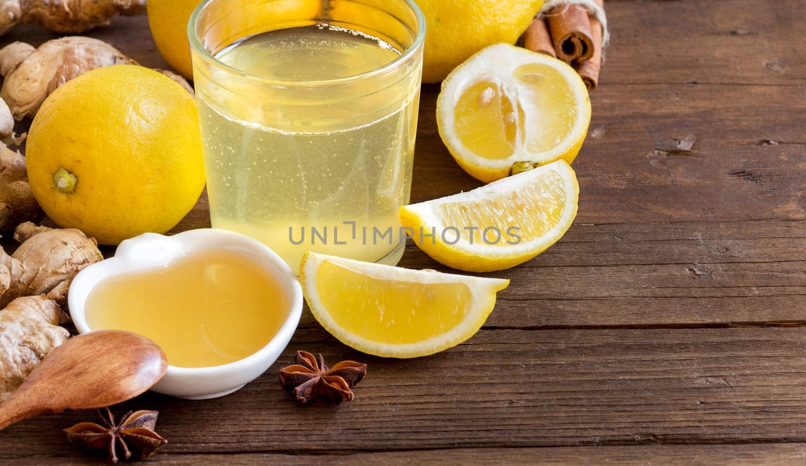 Honey, lemon, ginger tonic and ingridients on wood