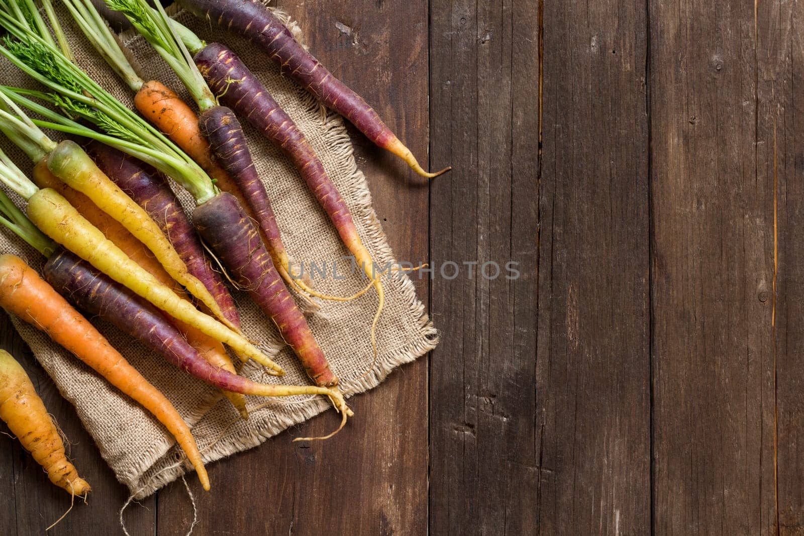 Fresh organic rainbow carrots on a wooden table