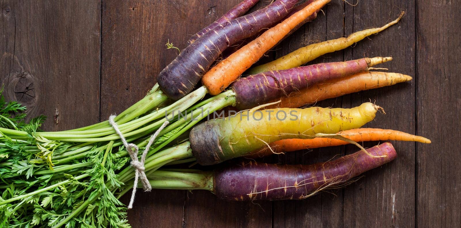 Fresh organic rainbow carrots on a wooden table