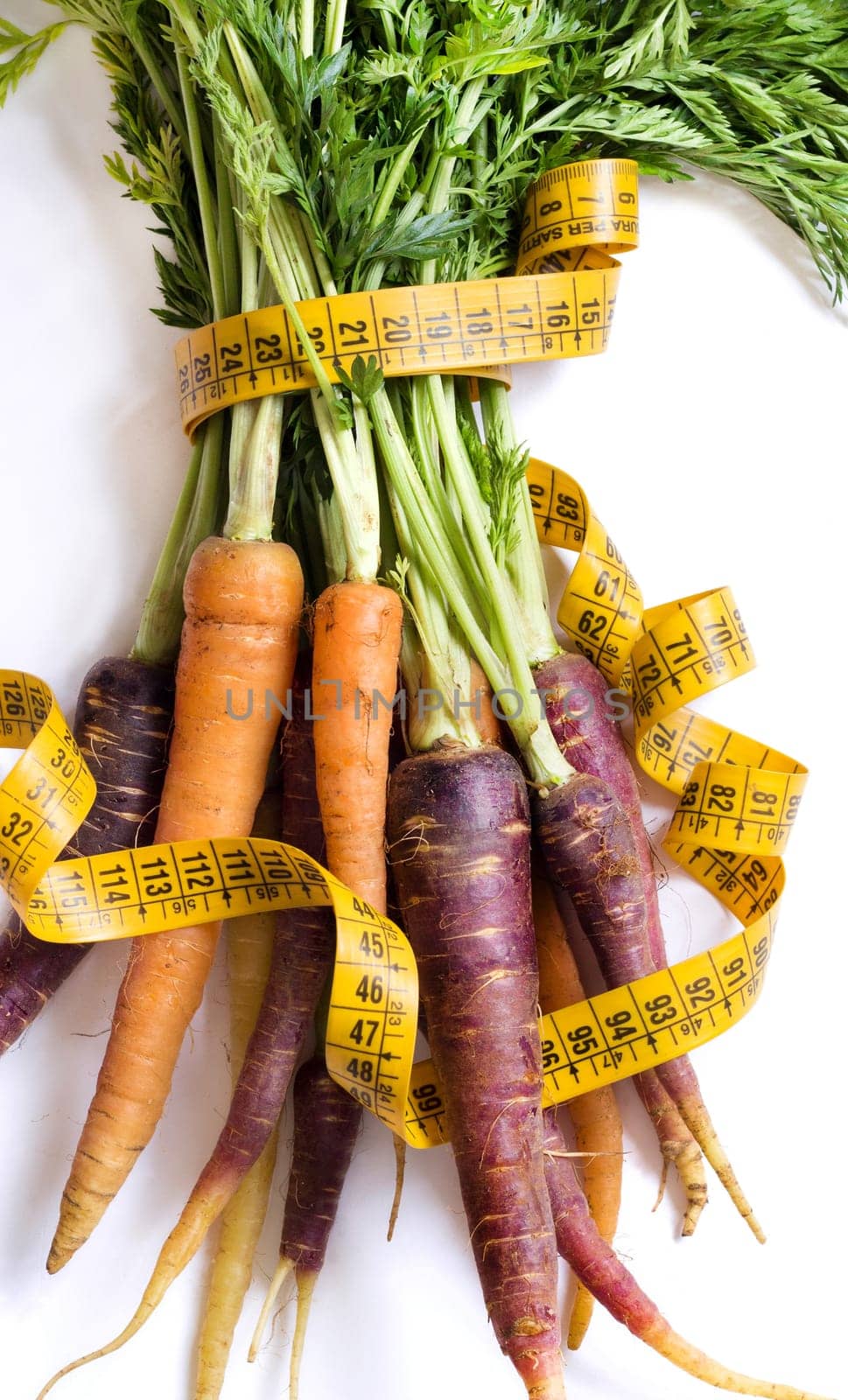 Fresh organic rainbow carrots and yellow measuring type