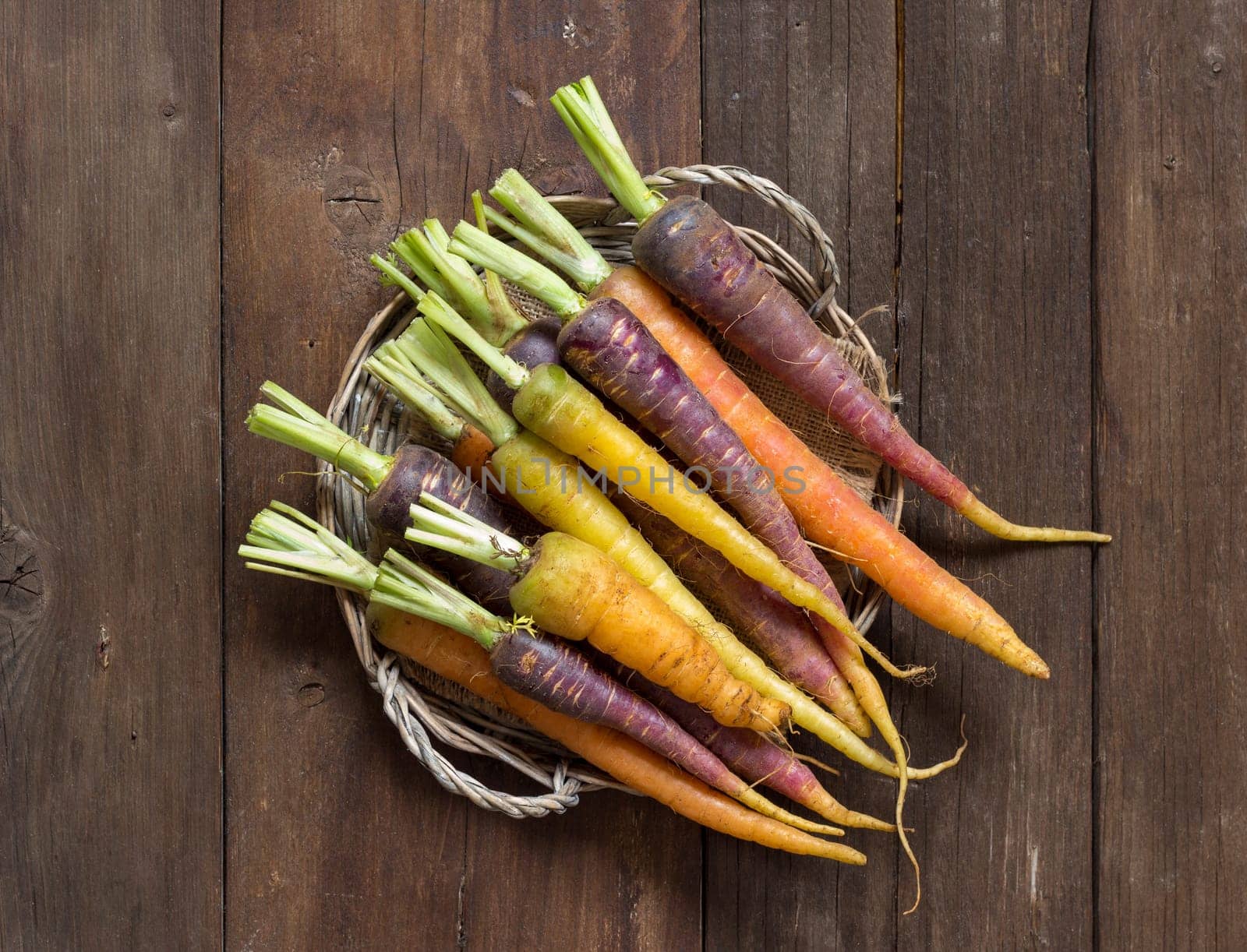 Fresh organic rainbow carrots on a wooden table