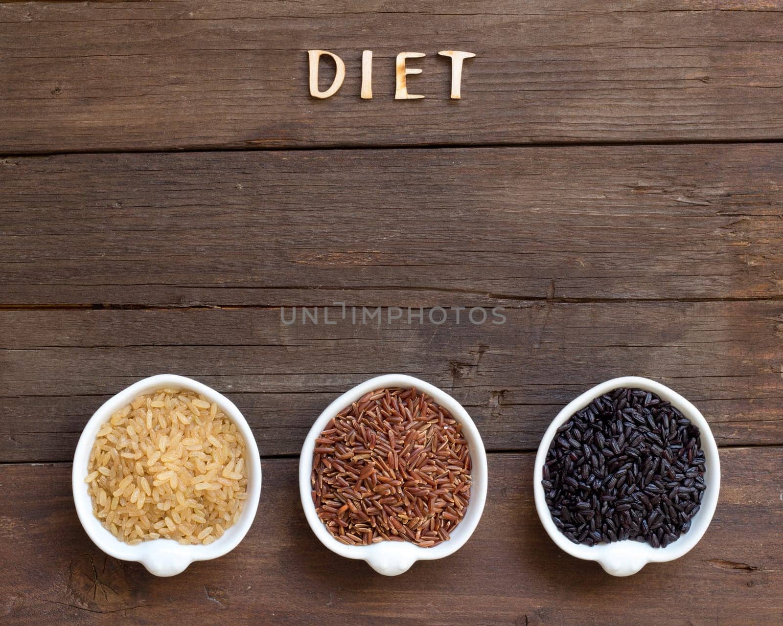 Variety of rice and word Diet on a wooden background