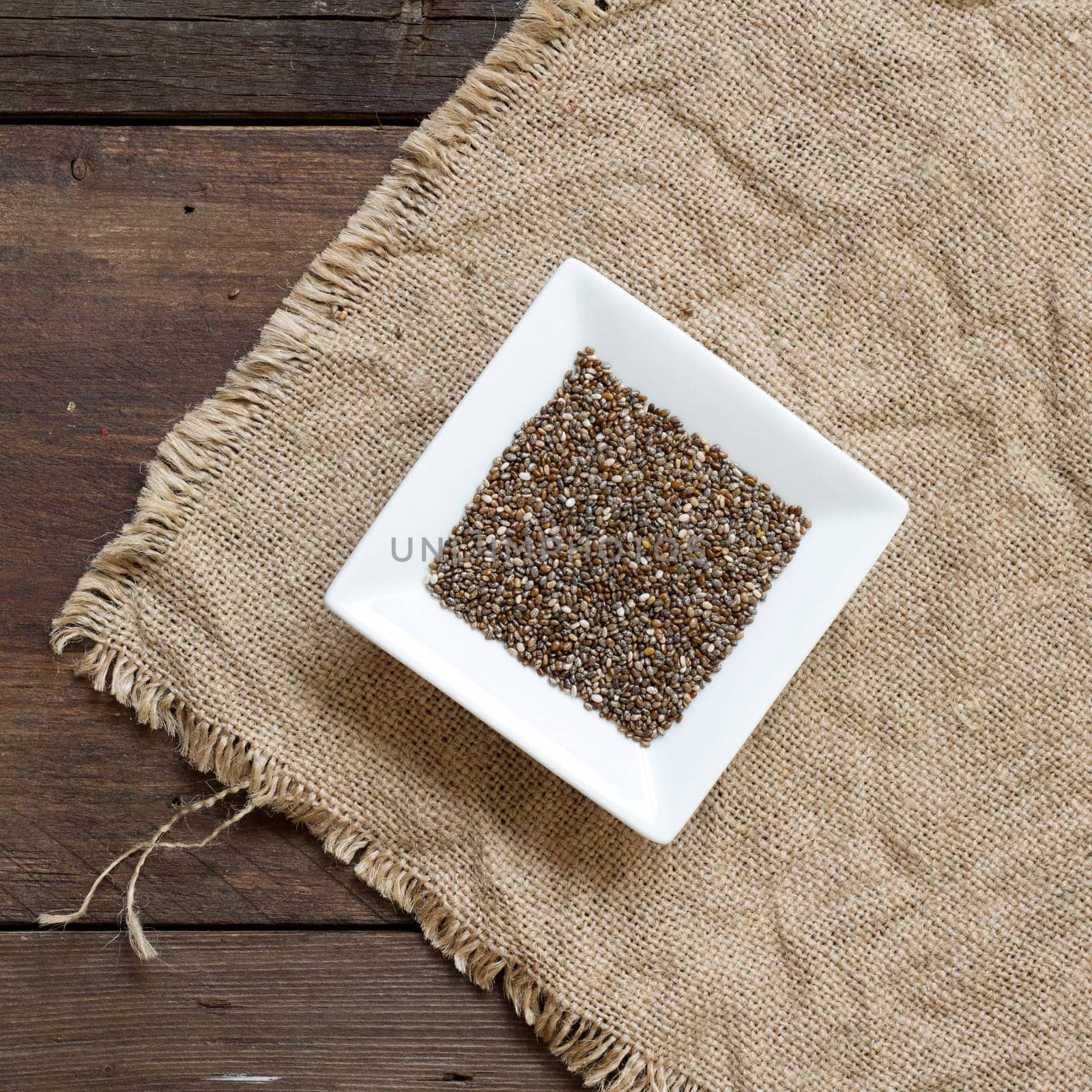 Chia seeds in bowl on a burlap background