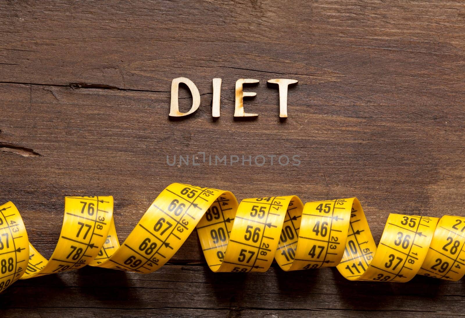 The word of Diet and measuring type on wooden background