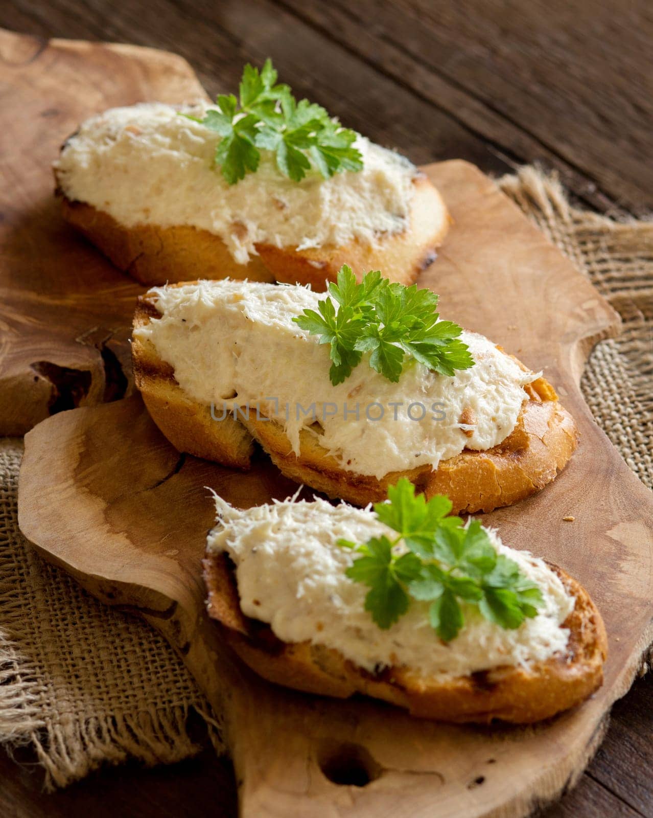 Toasted bread with a salted codfish mousse on wooden cutting board