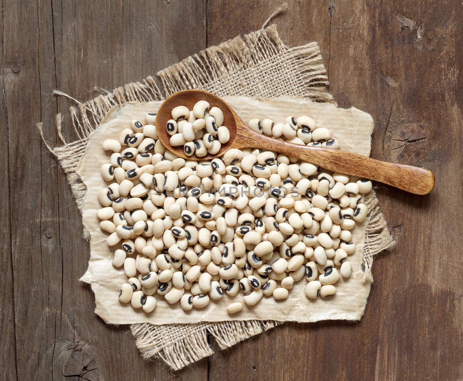 Black eyed peas with a spoon on a wooden table
