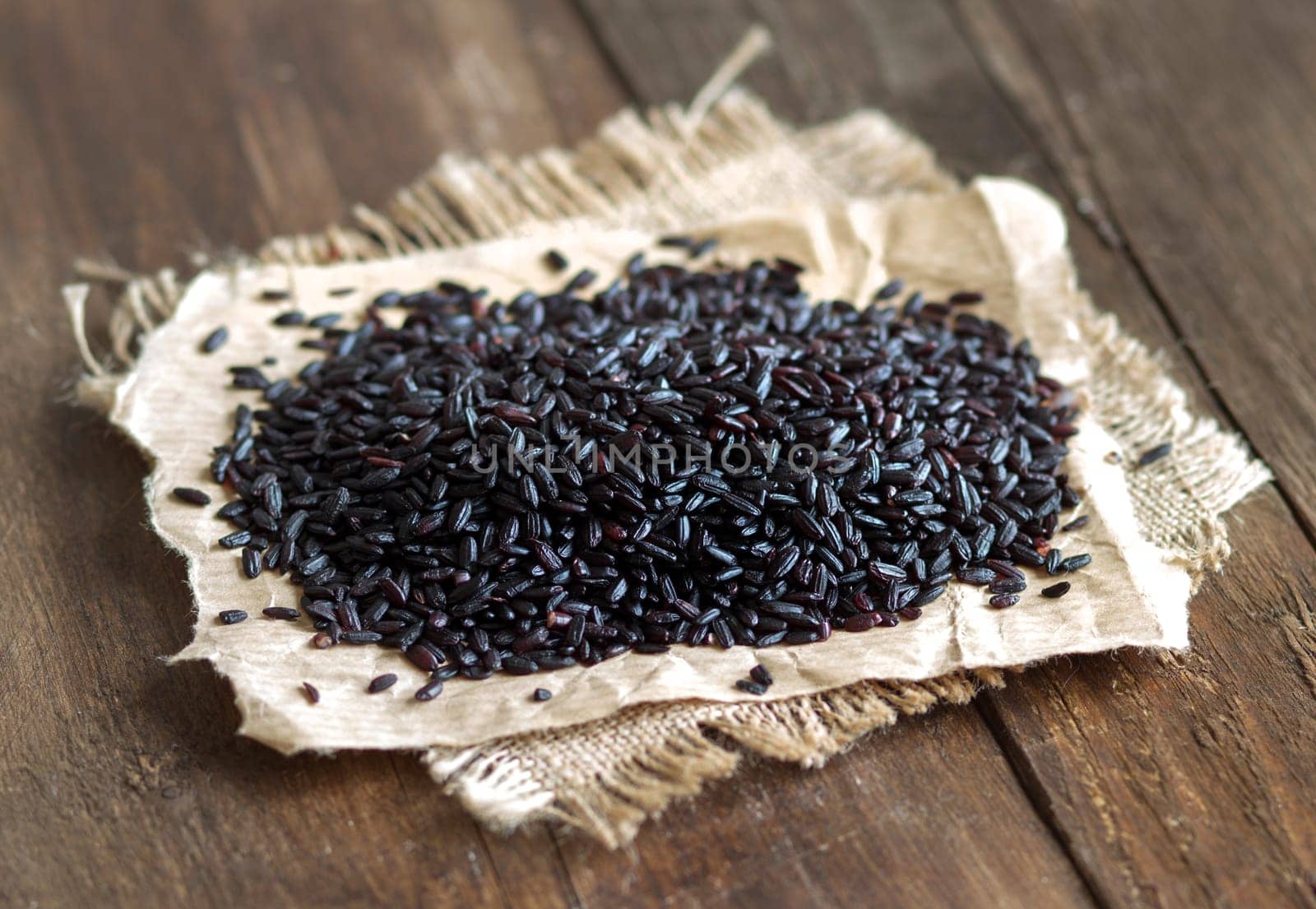 Black rice on a wooden table close up
