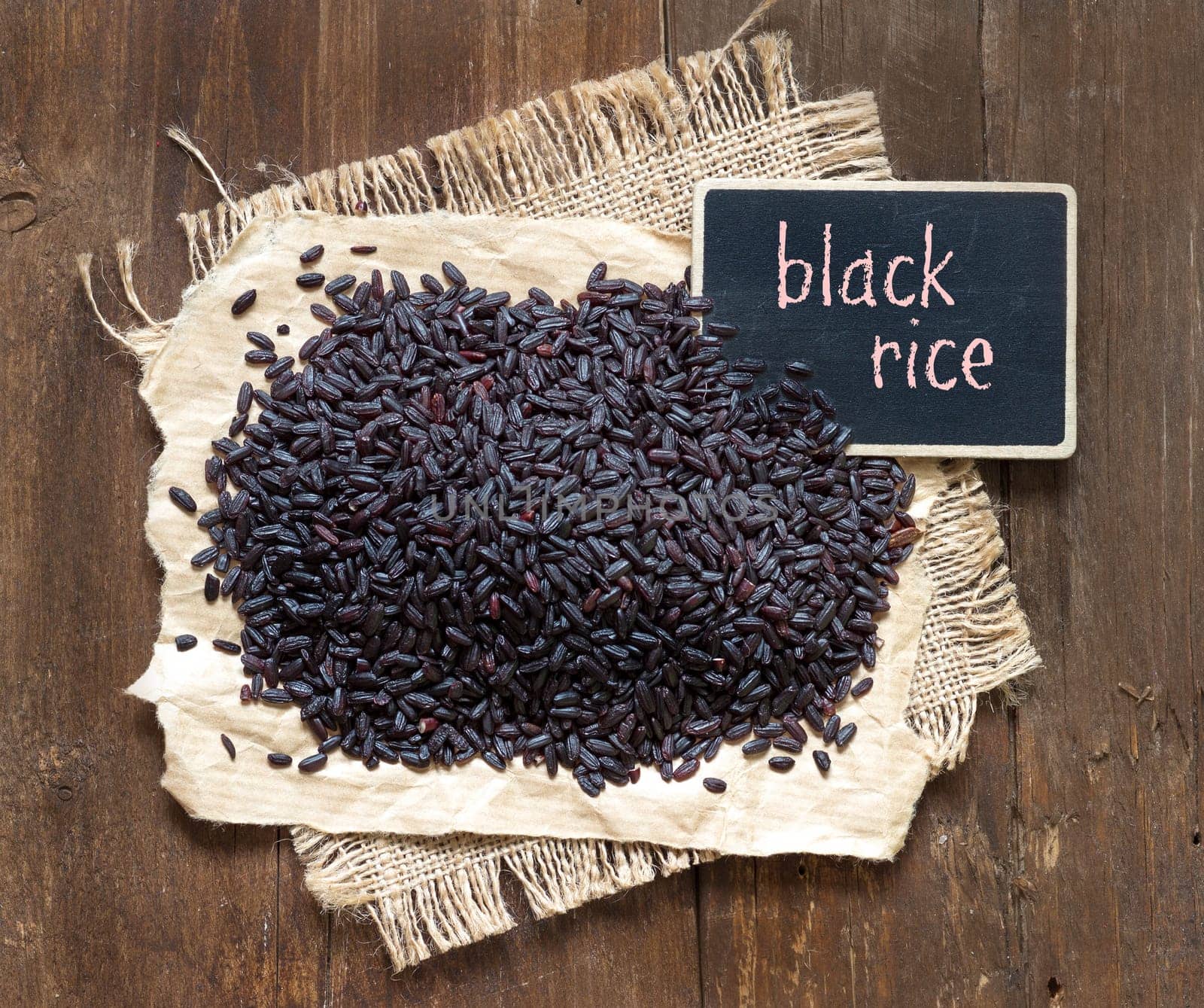 Black rice with small chalkboard on a wooden table