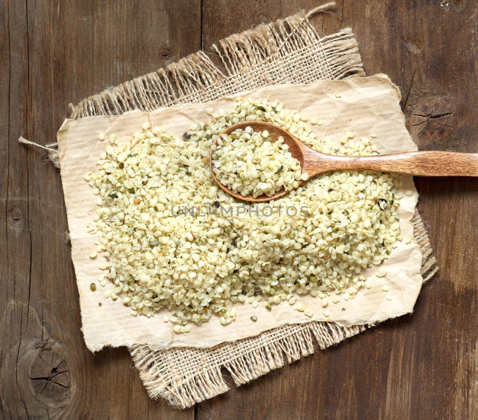 Hemp seeds with a spoon on a wooden table