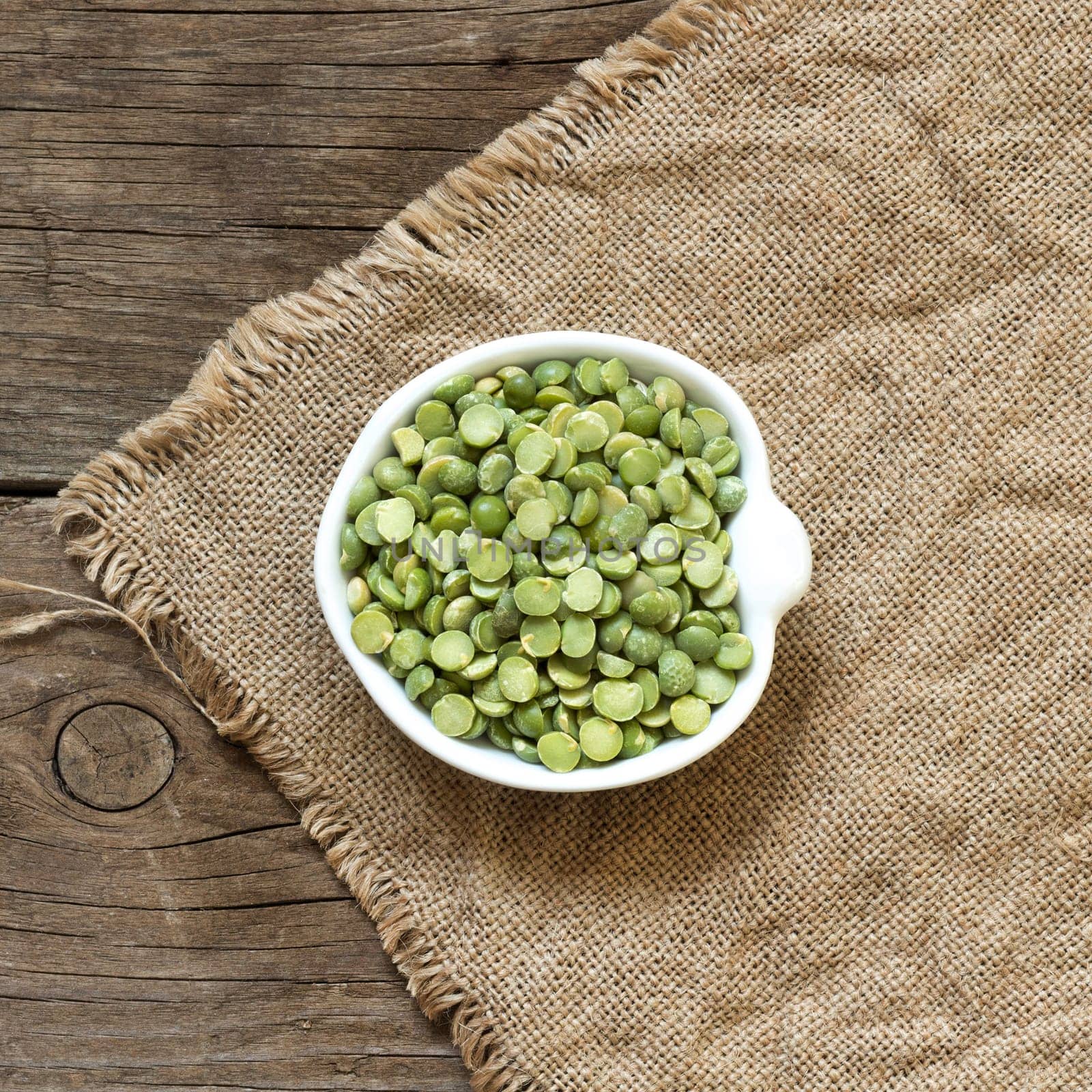 Dried Green Split Peas in a bowl on a wooden table