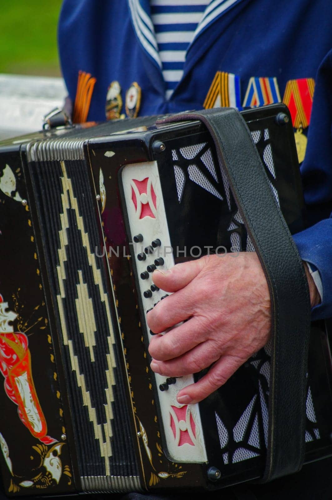 ST.PETERSBURG, RUSSIA - MAY 9, 2014: A very pleasent veteran plays accordion on the 69-th anniversary of the victory in the World War II on May 9, 2013, St.Petersburg, Russia