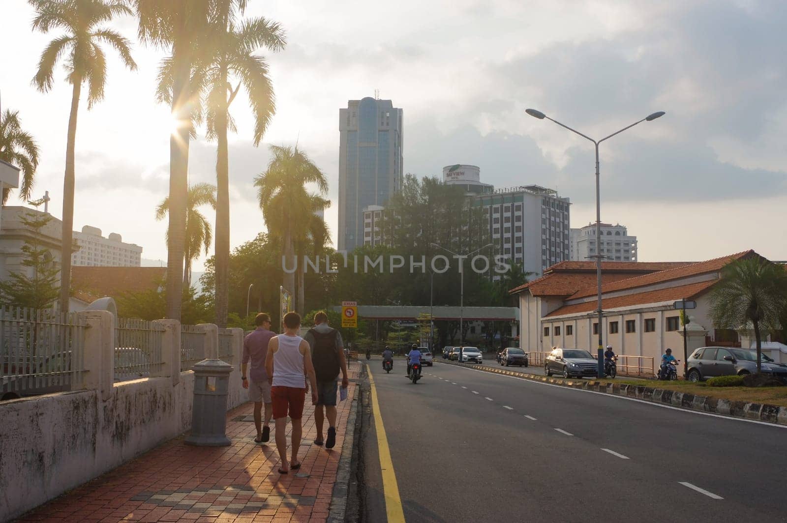 tourist at a city street in Penang, Georg Town, at dusk with light trails and traffic sign, Malaysia.