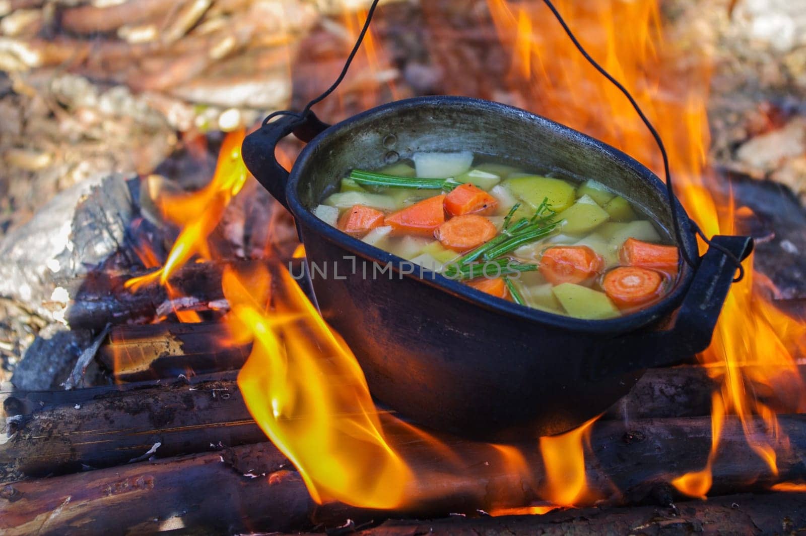 vegetable soup in old tourist pot at fire place Summer trekking activity