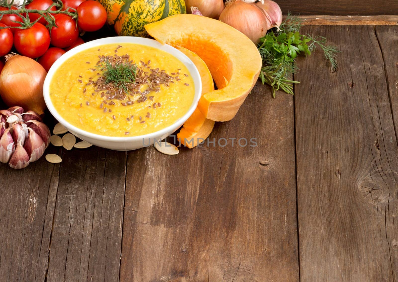 Fresh tomatoe soup with vegetables on a wooden table