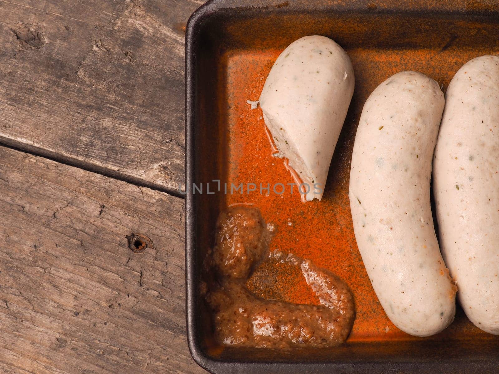 Delicious Bavarian white sausages with sweet mustard in a rustic ceramic bowl