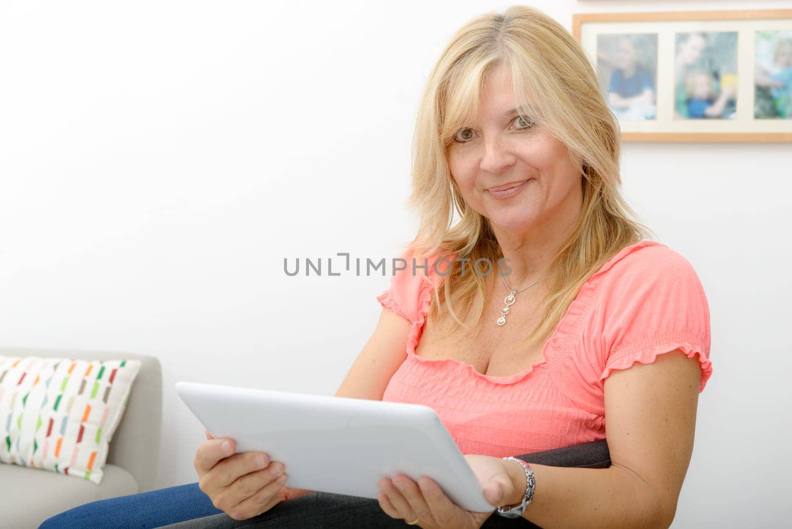 a beautiful mature woman using electronic tablet at home