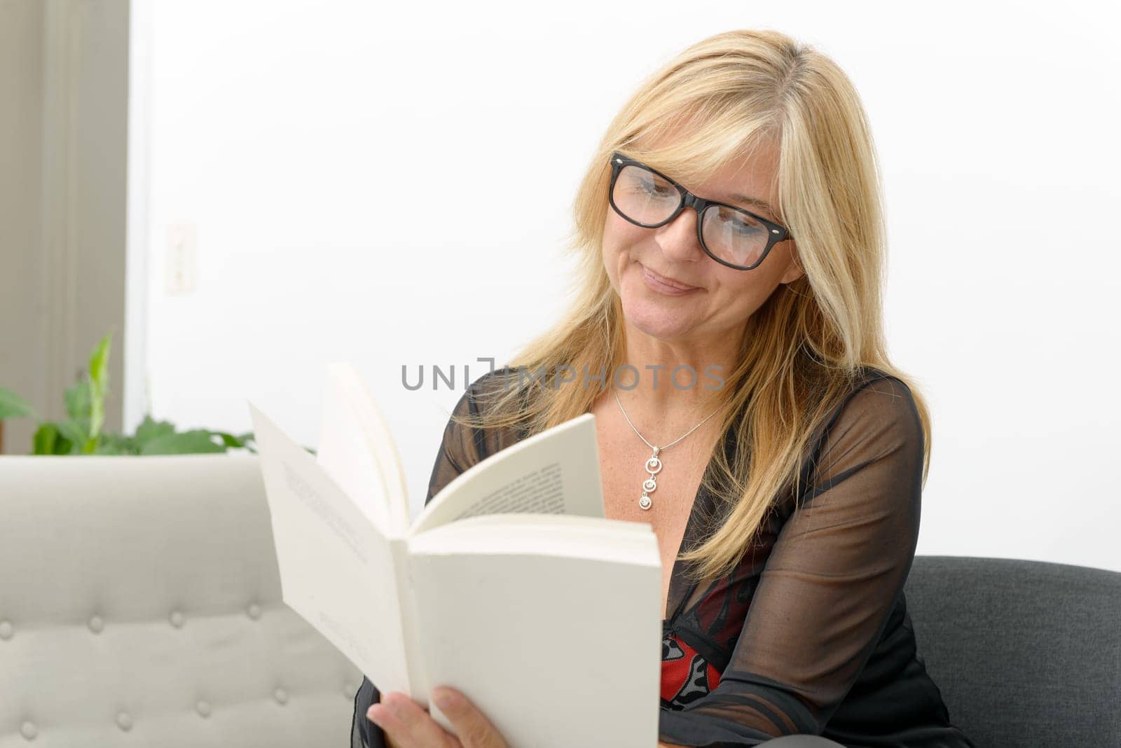 a mature blond woman reading a book