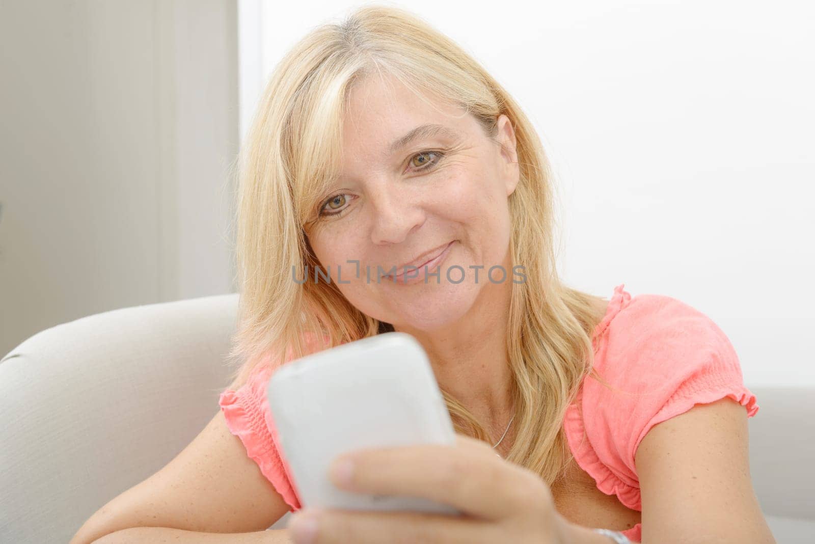 Smiling senior woman using smartphone at home